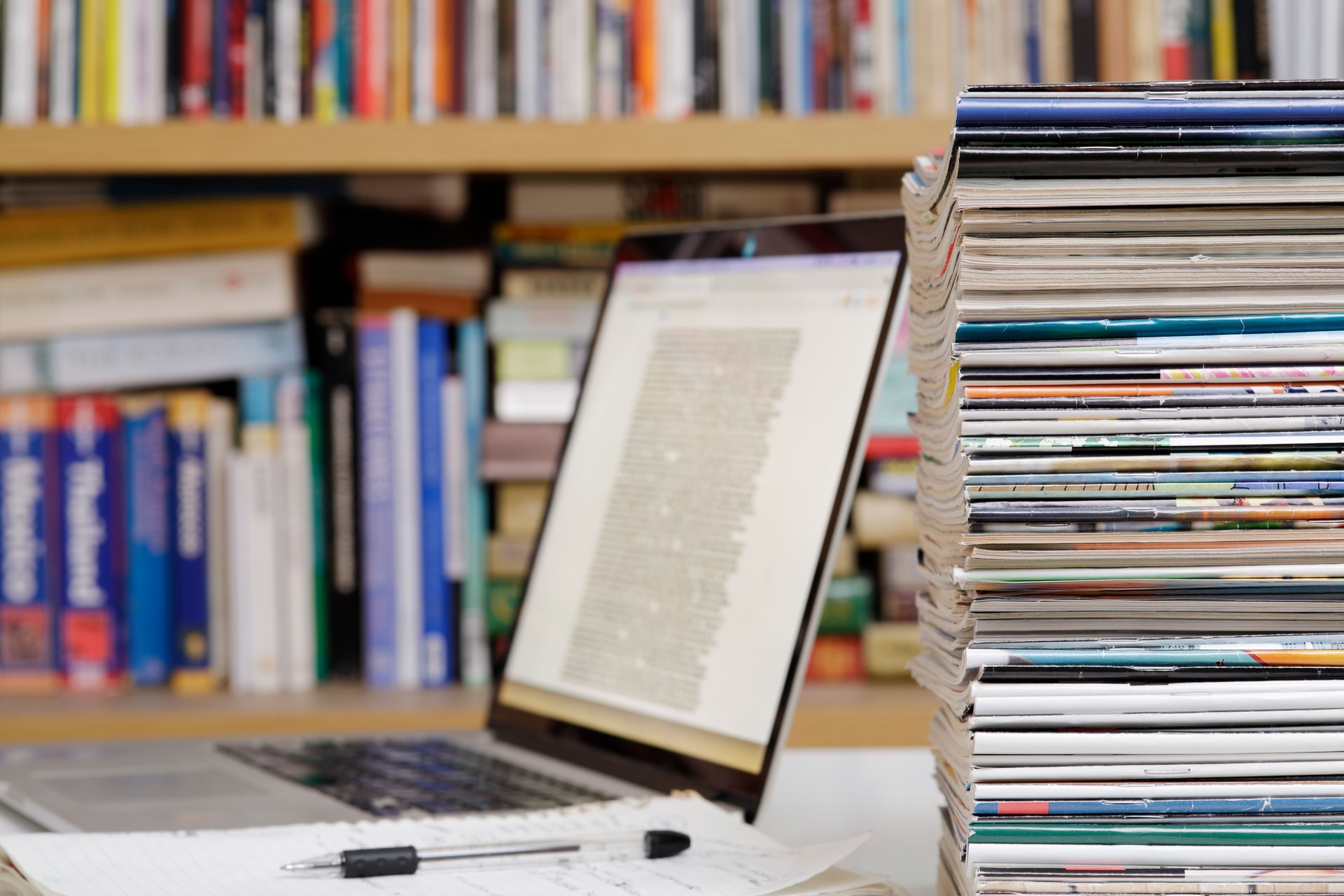 Stack of magazines and laptop computer