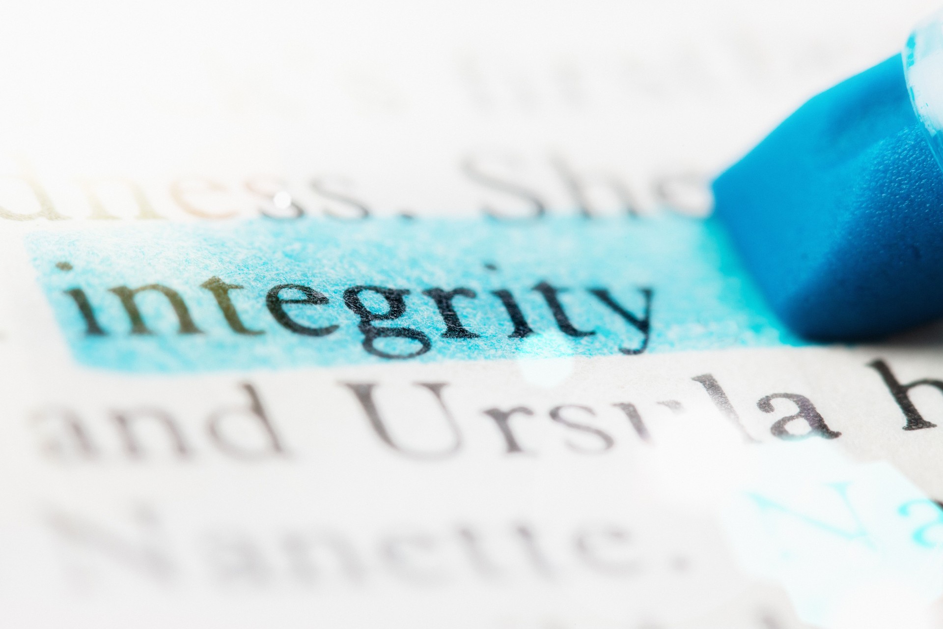 The word 'integrity' highlighted on defocused printed page